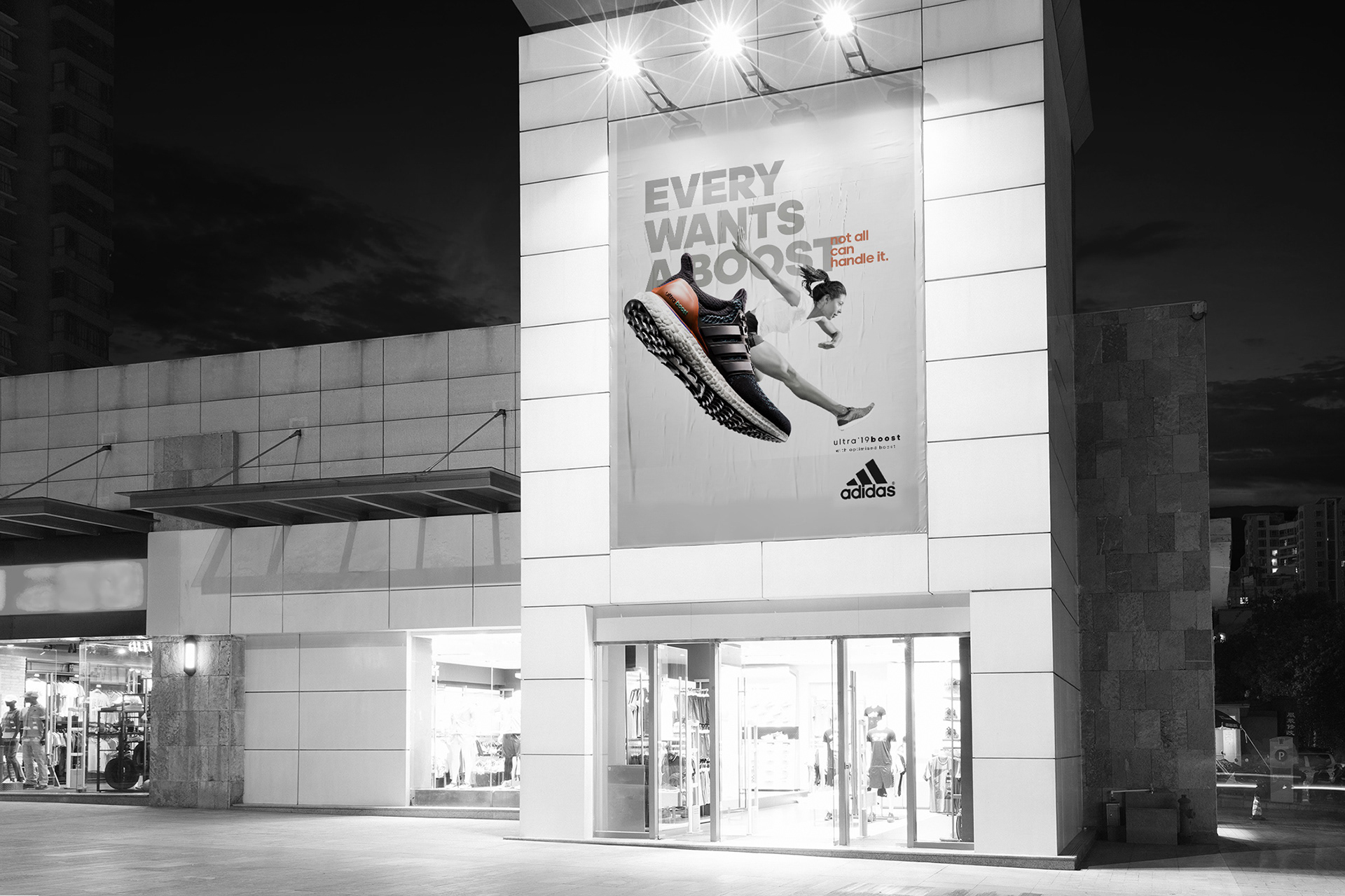 Adidas Ultraboost building-wall banner at a storefront at night